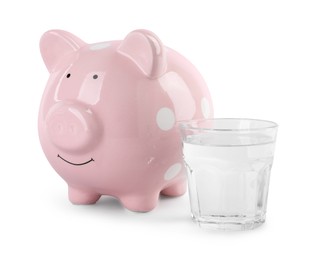 Photo of Water scarcity concept. Piggy bank and glass of drink isolated on white