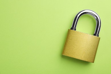 Modern padlock on green background, top view. Space for text