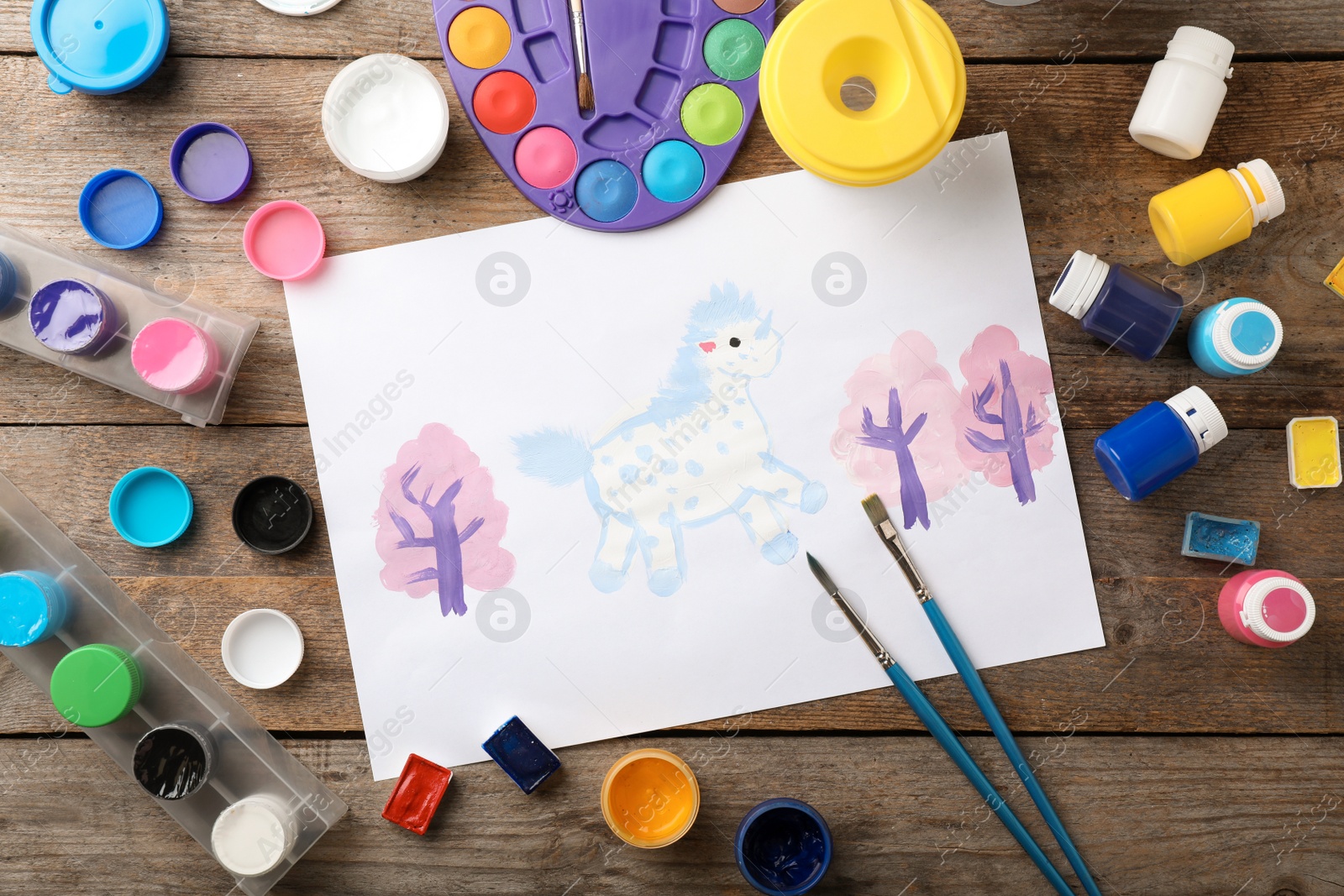 Photo of Flat lay composition with child's painting of unicorn on table