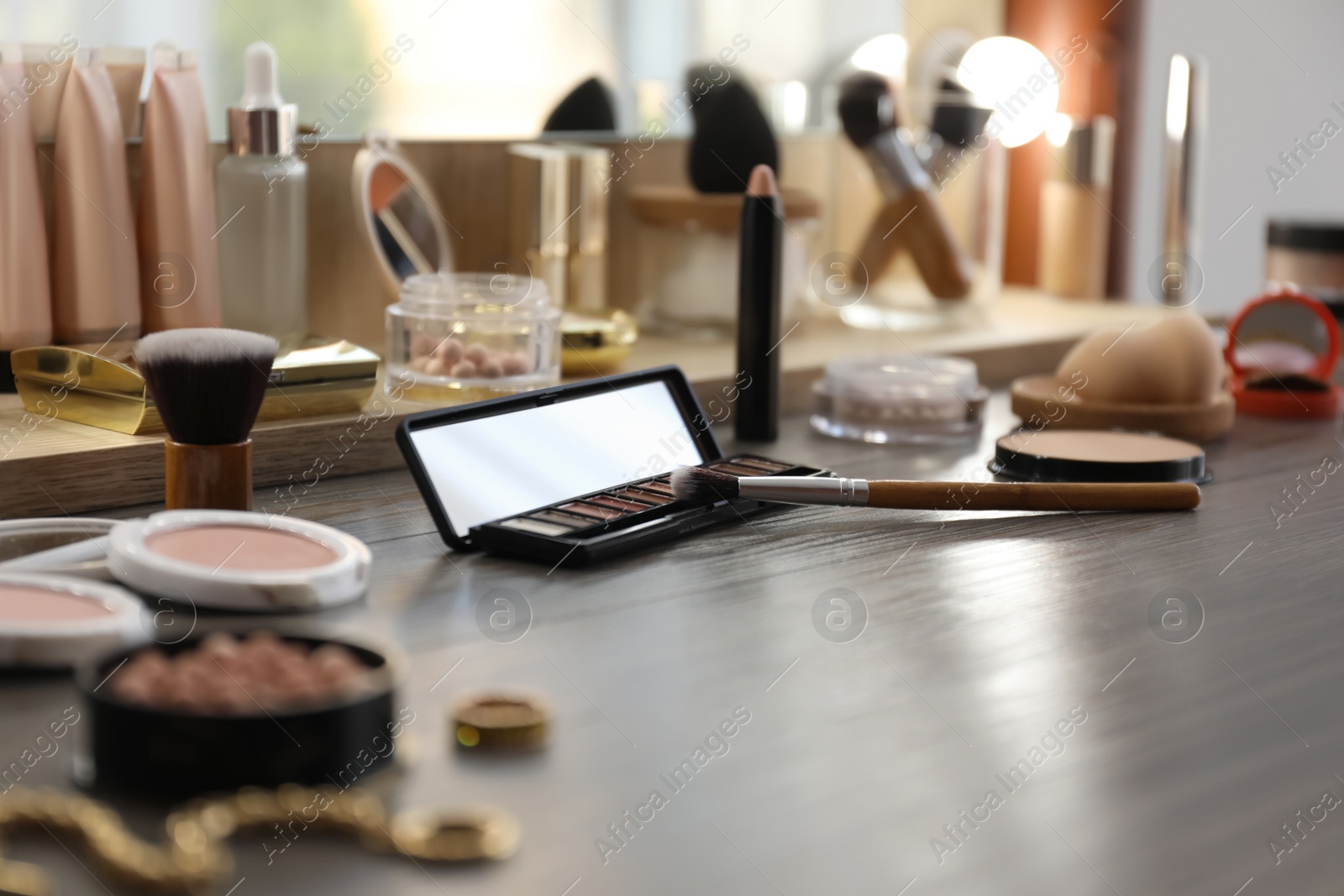 Photo of Many different cosmetic products on dressing table indoors