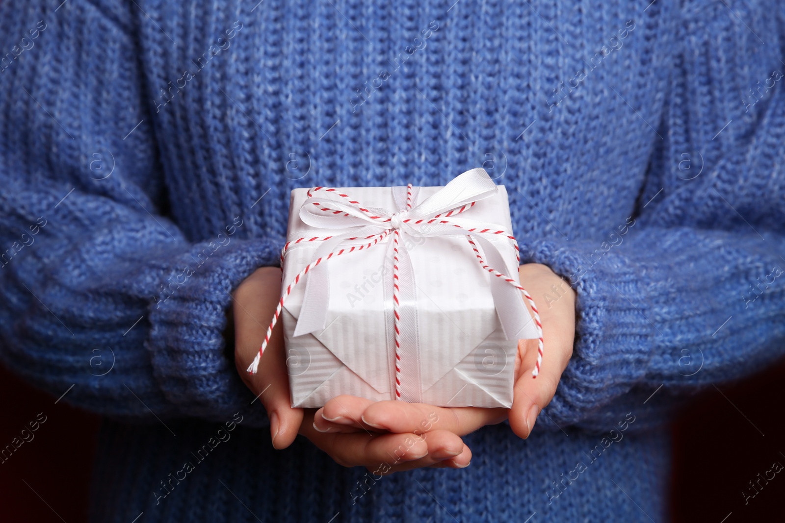 Photo of Woman holding white Christmas gift box, closeup