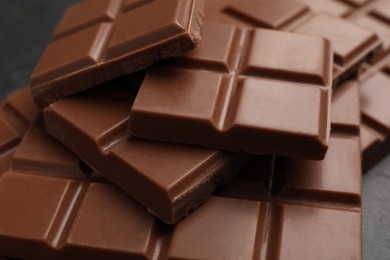 Photo of Delicious milk chocolate on black table, closeup