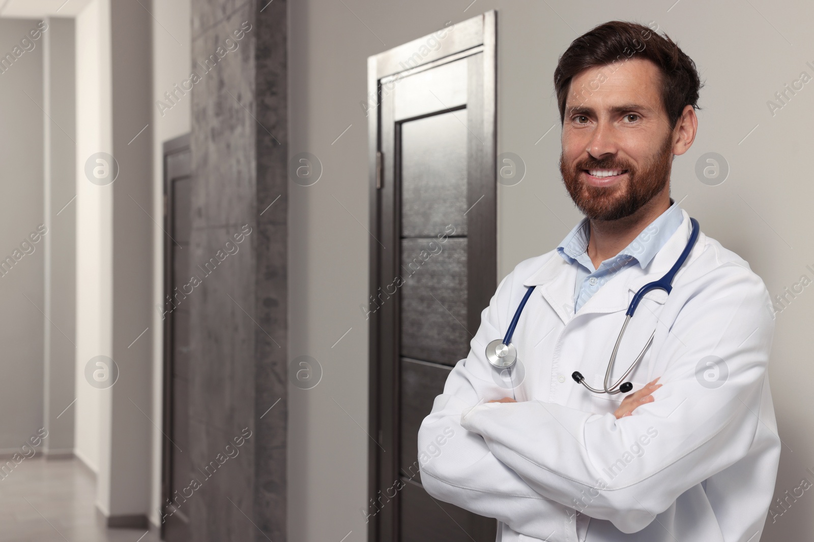 Photo of Doctor in white coat with stethoscope indoors. Space for text