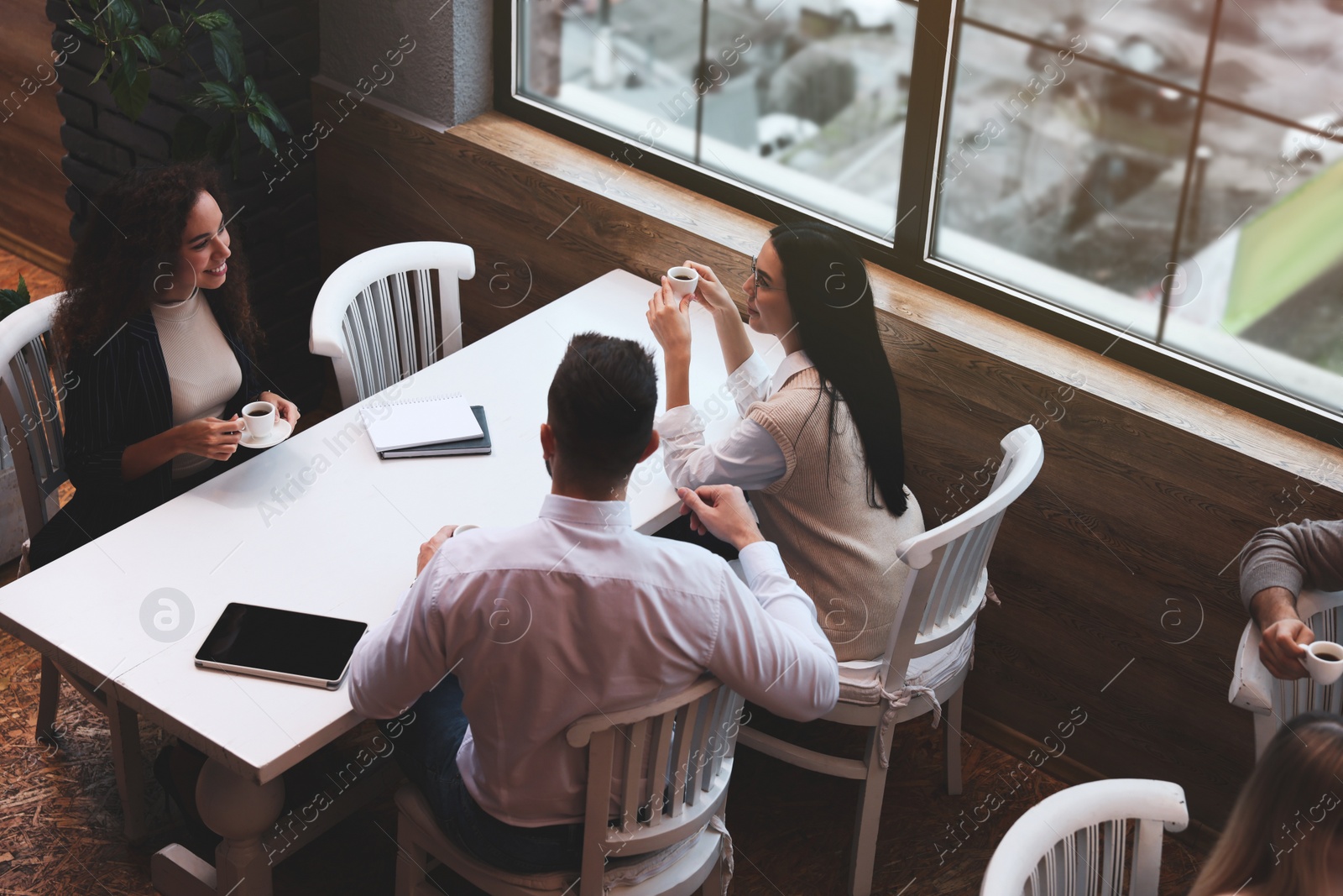 Photo of Group of coworkers having coffee break in cafe