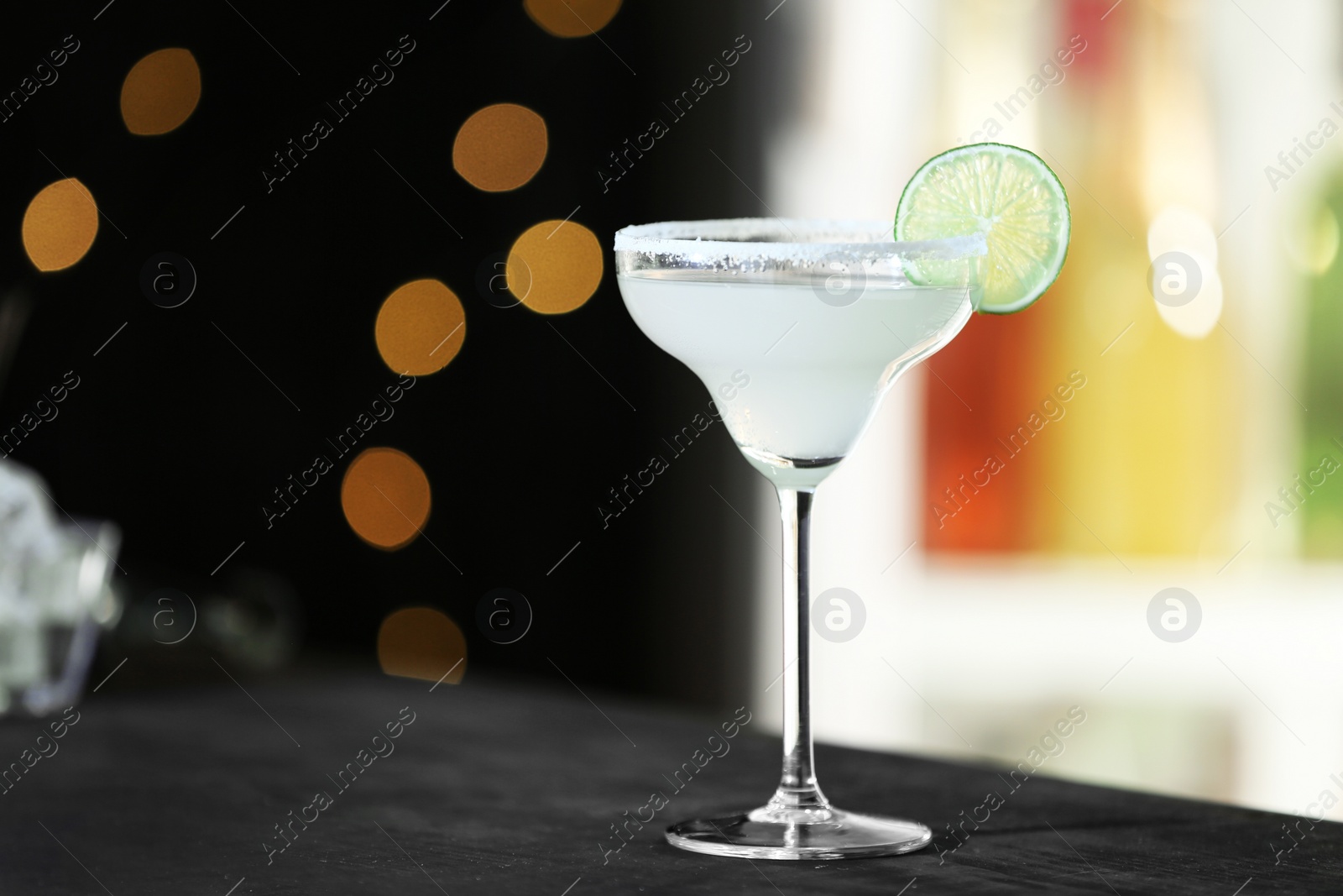 Photo of Fresh alcoholic cocktail with lemon and sugar on bar counter