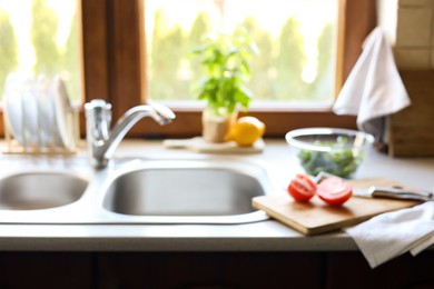 Photo of Blurred view of stylish kitchen interior with sink and products