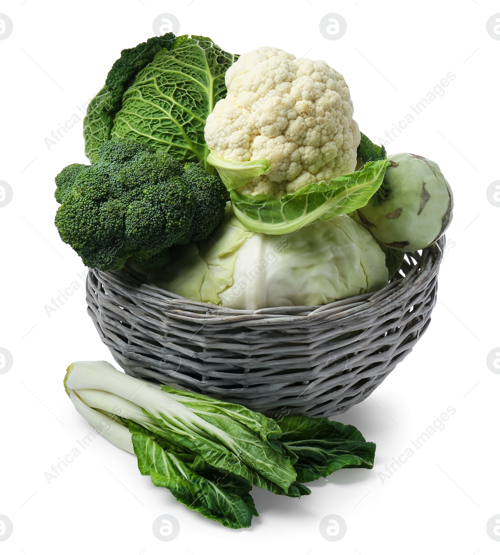 Photo of Wicker basket with different types of fresh cabbage on white background