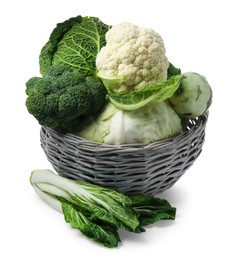 Wicker basket with different types of fresh cabbage on white background