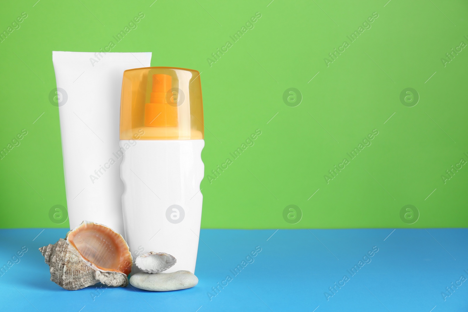 Photo of Different suntan products and seashells on color background. Space for text