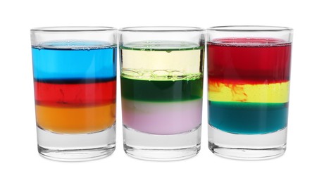 Different shooters in shot glasses isolated on white. Alcohol drink