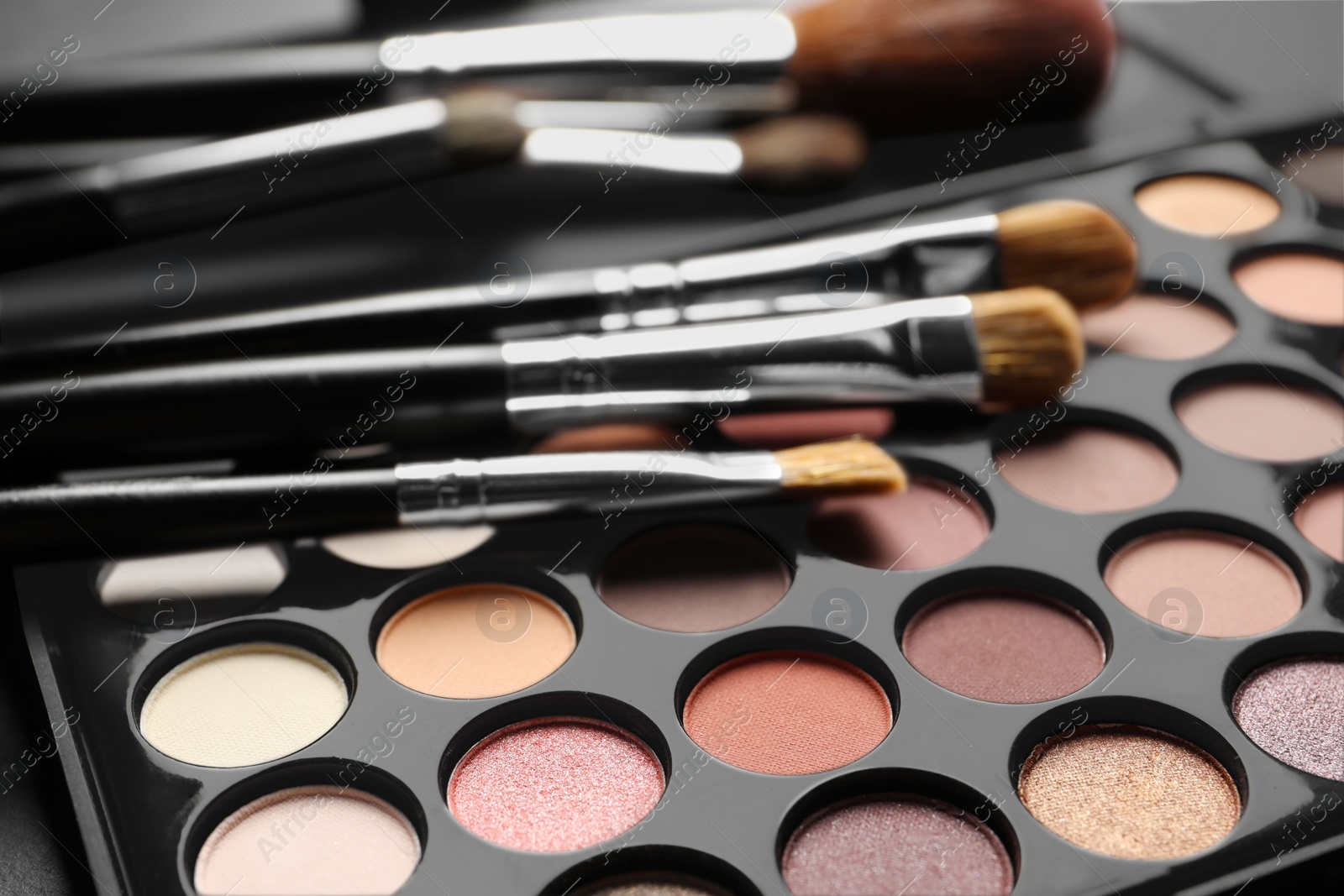 Photo of Beautiful eye shadow palette with brushes, closeup