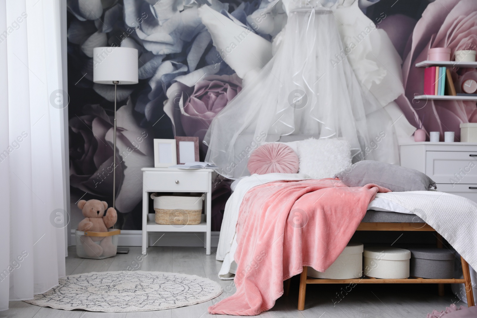 Photo of Teenage girl's room interior with comfortable bed and floral wallpaper. Idea for stylish design