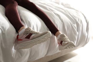 Photo of Lazy young woman sleeping on bed instead of morning training, closeup