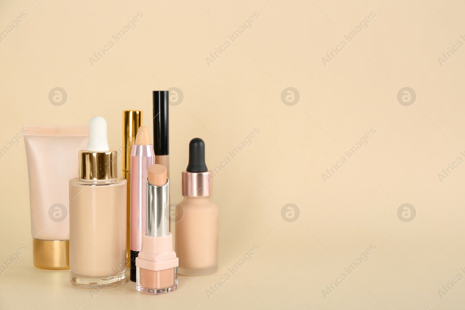Photo of Foundation makeup products on beige background, space for text. Decorative cosmetics