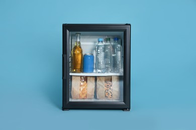 Photo of Mini bar filled with food and drinks on turquoise background