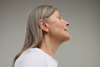 Photo of Beautiful woman with healthy skin on grey background, low angle view