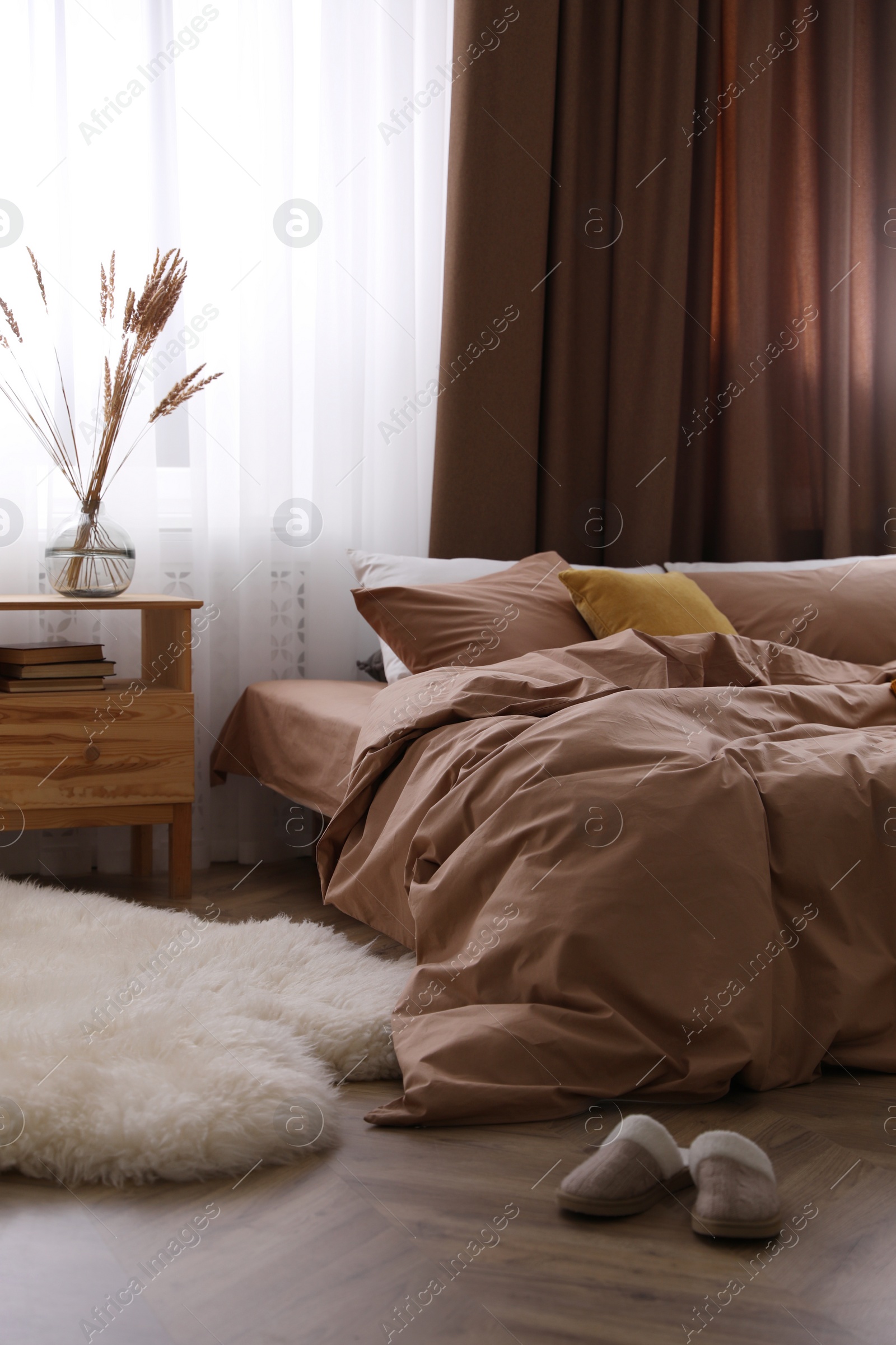 Photo of Bed with brown linens in stylish room interior