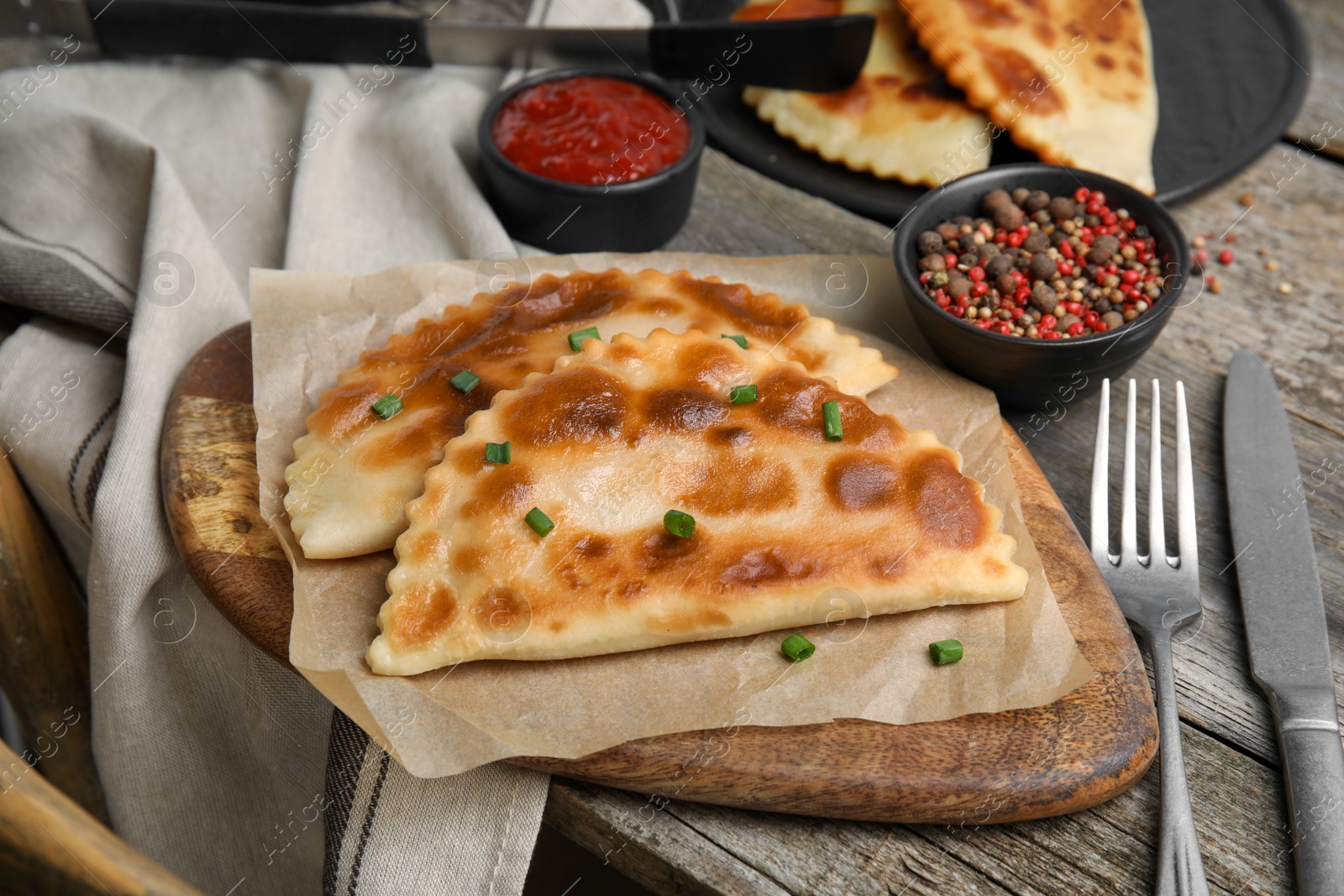 Photo of Delicious fried chebureki served on wooden table