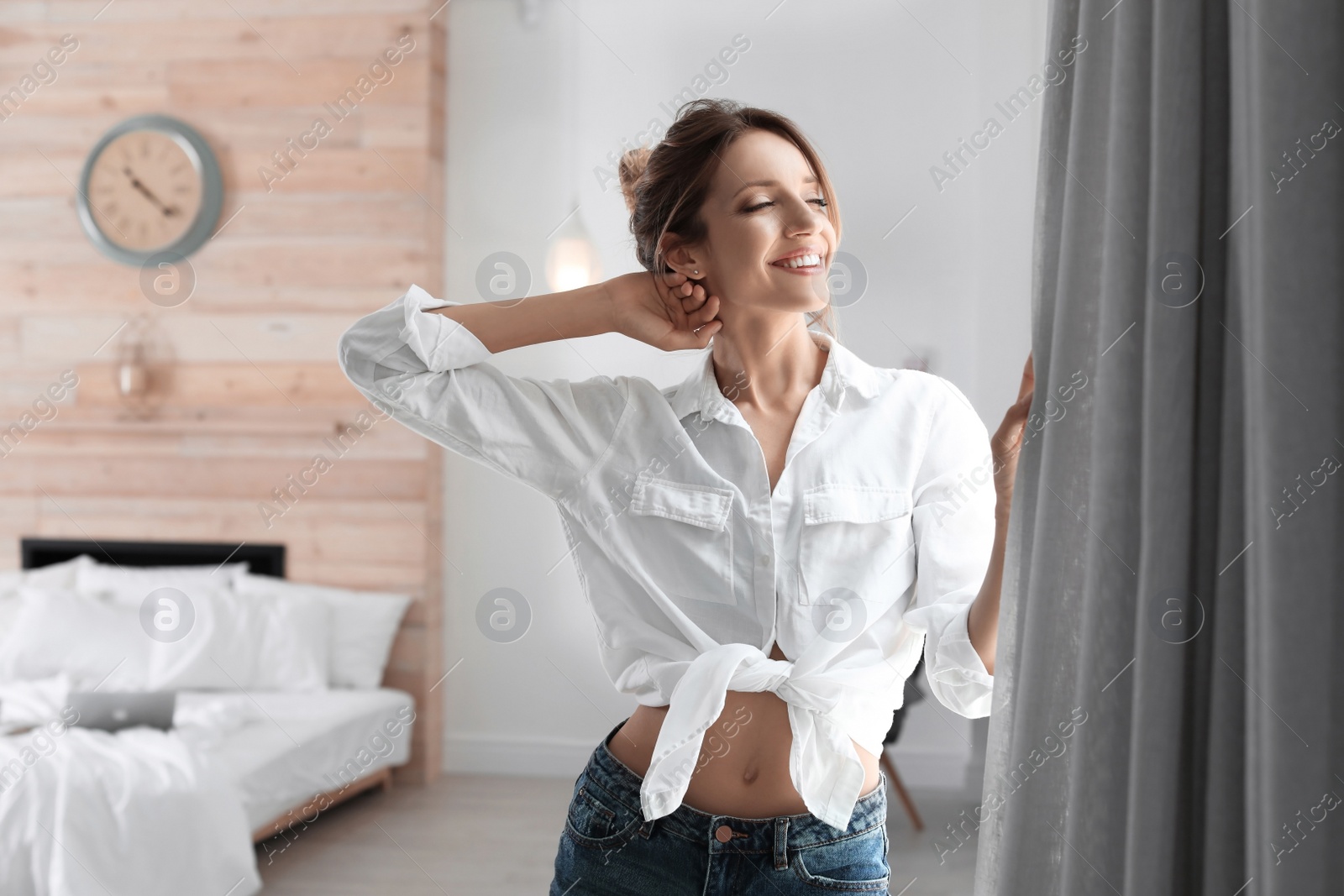 Photo of Young happy woman near window at home. Lazy morning