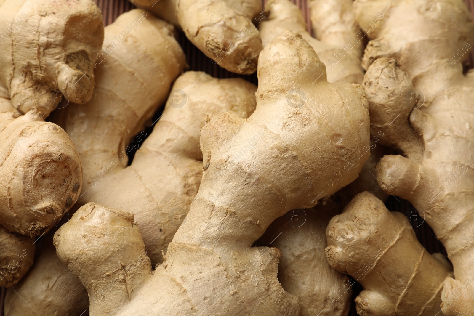 Photo of Aromatic fresh ginger as background, closeup view