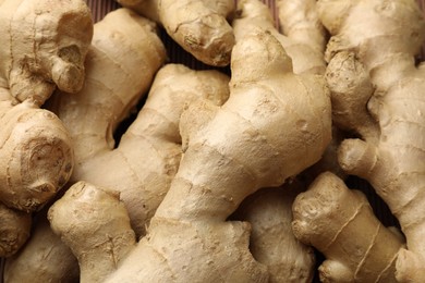 Photo of Aromatic fresh ginger as background, closeup view