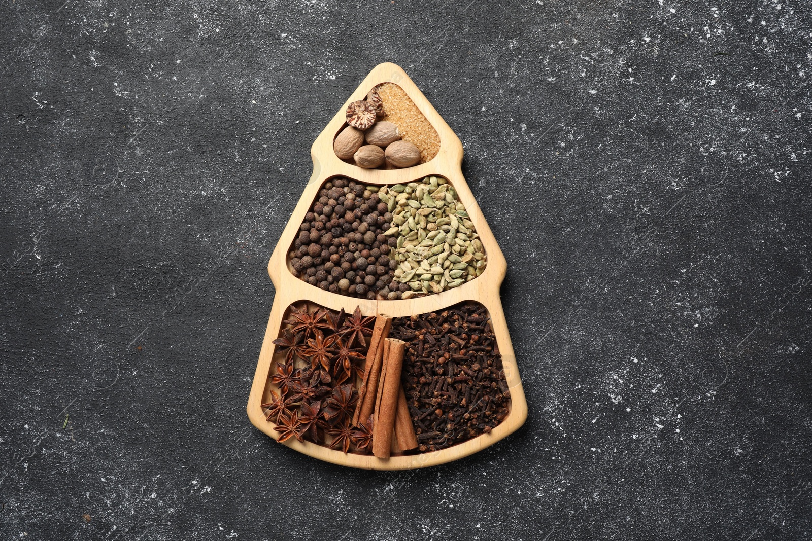 Photo of Different spices and nuts on dark gray textured table, top view