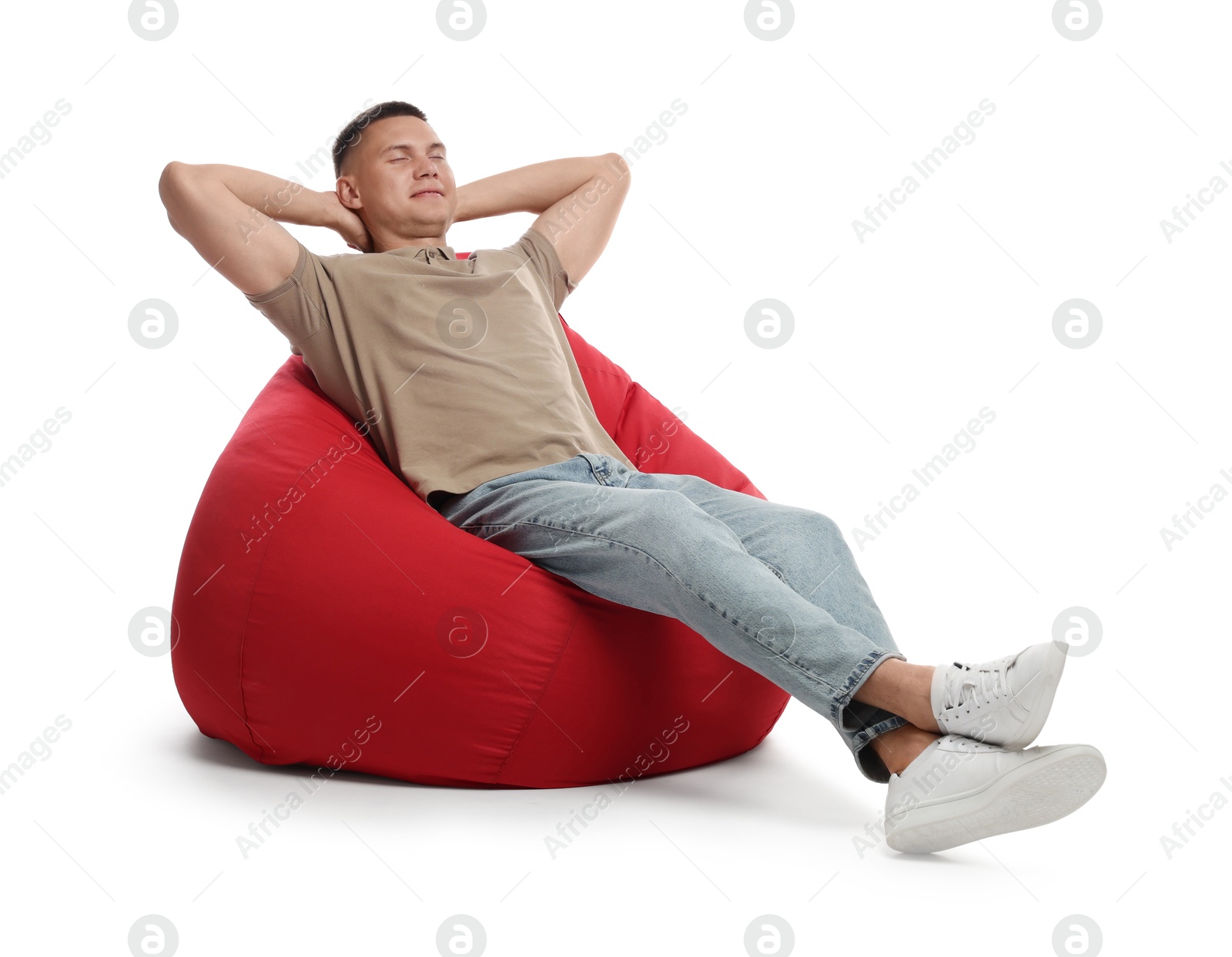 Photo of Handsome man resting on red bean bag chair against white background