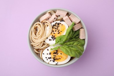 Photo of Bowl of delicious ramen with meat and egg on violet table, top view. Noodle soup