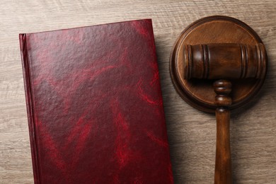 Photo of Law. Book and gavel on wooden table, top view