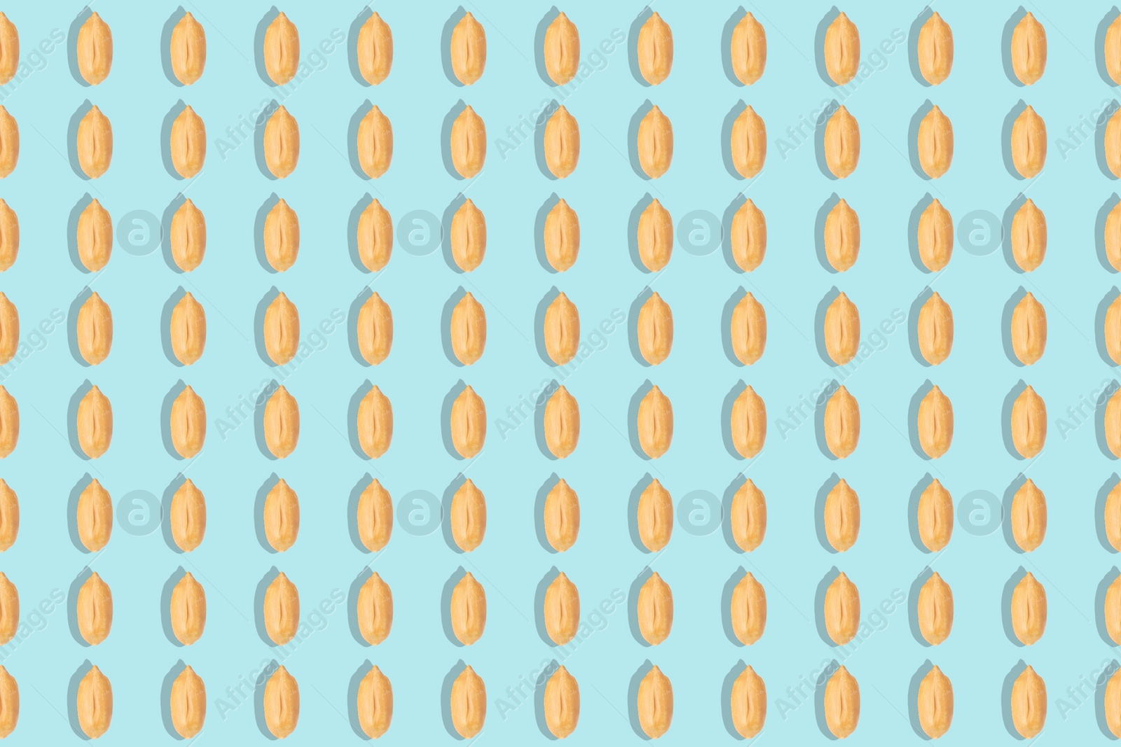 Image of Pattern of peeled peanuts on turquoise background