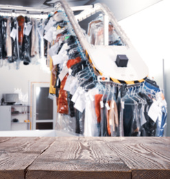 Image of Empty wooden surface and blurred view of dry-cleaner's, space for text