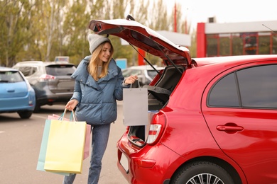 Woman with shopping bags near her car outdoors