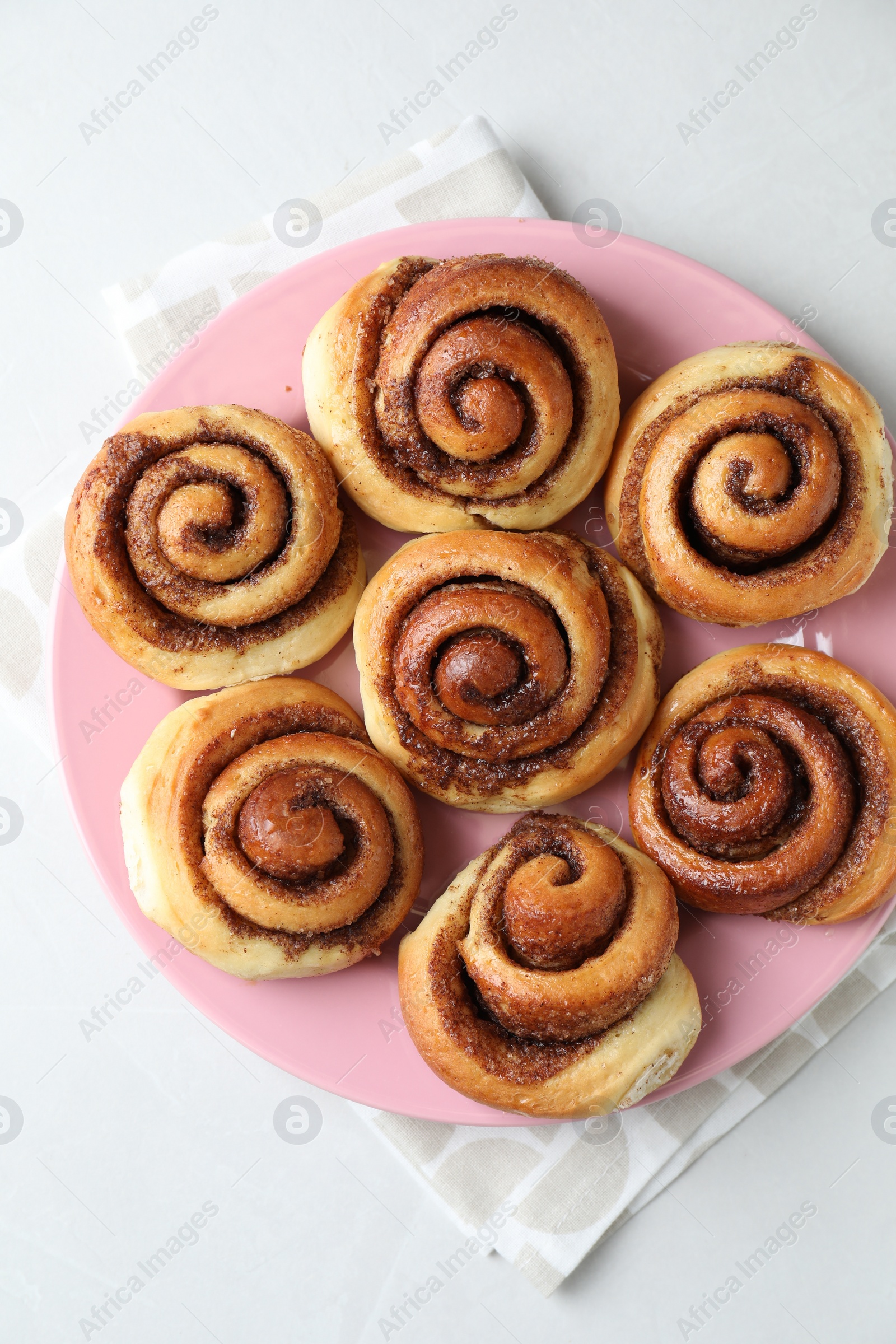 Photo of Many tasty cinnamon rolls on white table, top view