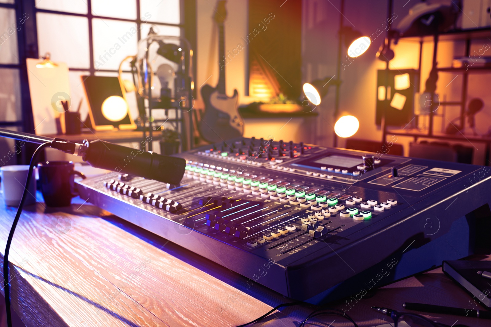 Photo of Microphone over professional mixing console on table in radio studio