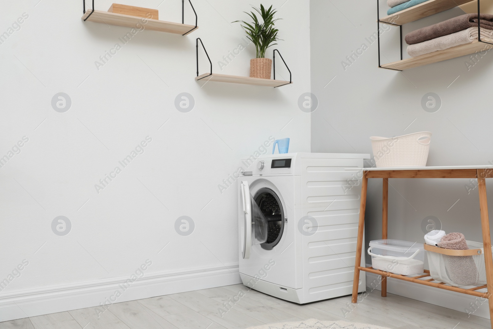 Photo of Modern washing machine in laundry room interior. Space for design