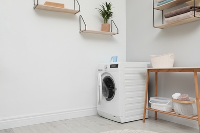 Photo of Modern washing machine in laundry room interior. Space for design