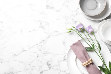 Photo of Flat lay composition with beautiful dishware and flowers on white marble table. Space for text