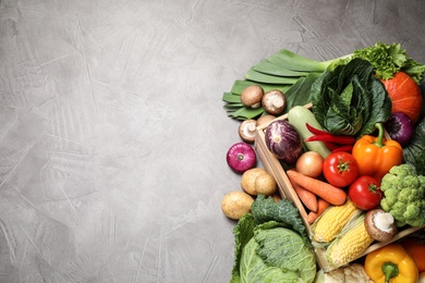 Photo of Flat lay composition with fresh vegetables on grey table, space for text