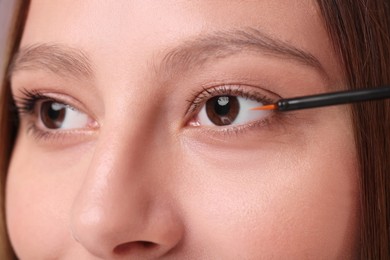 Woman applying serum onto eyelashes, closeup view