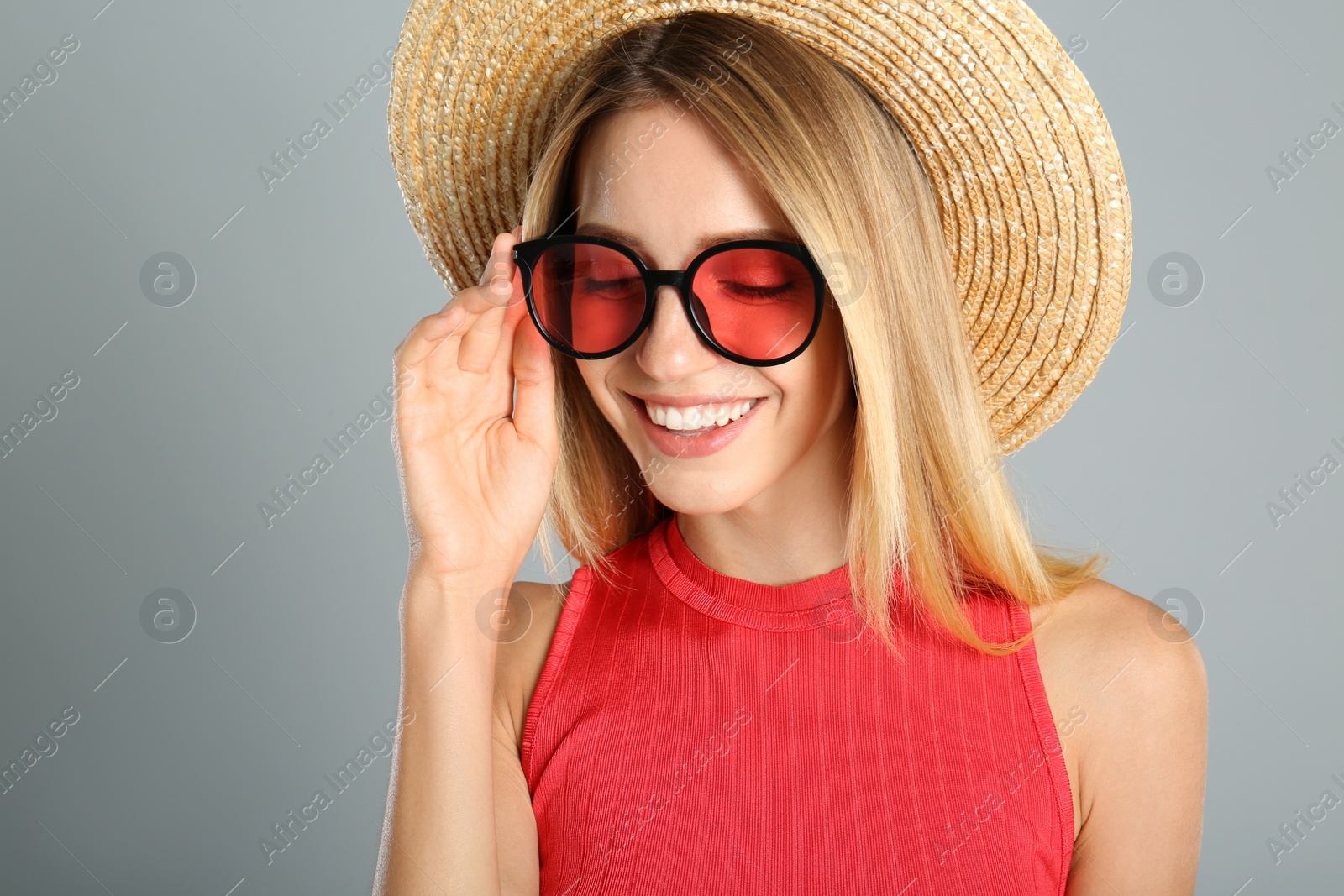 Photo of Beautiful woman in stylish sunglasses on grey background