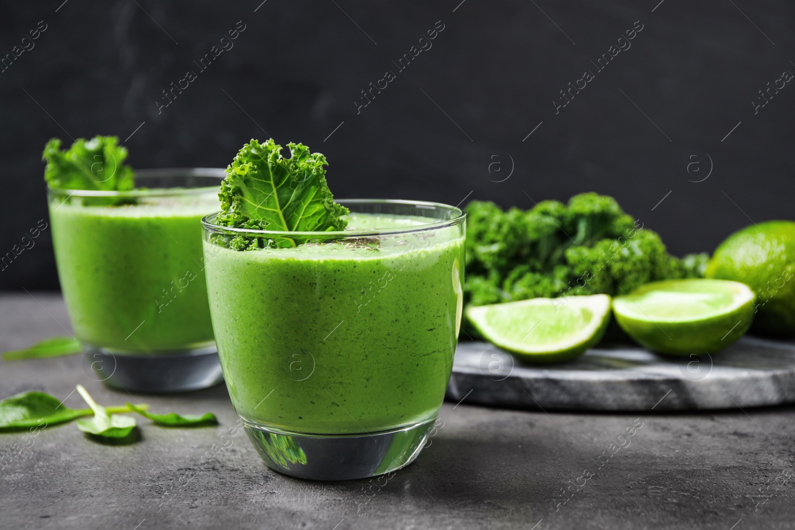 Photo of Tasty kale smoothie on grey table, closeup