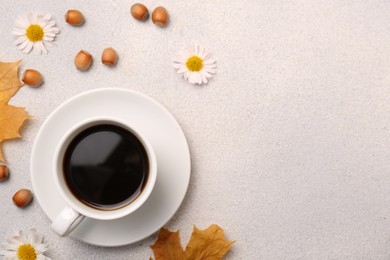 Photo of Flat lay composition with cup of hot drink and autumn leaves on light grey textured table. Space for text