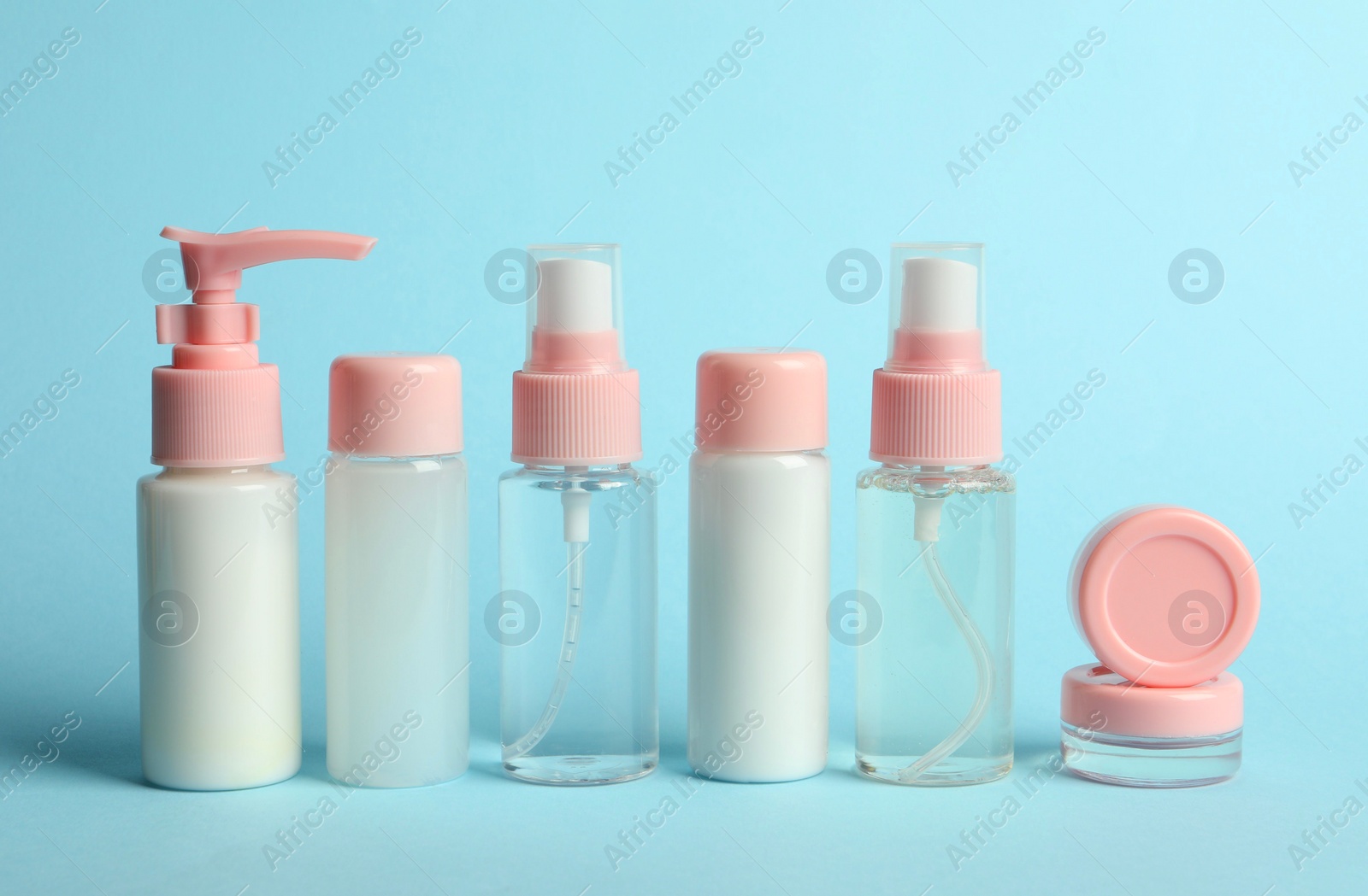 Photo of Cosmetic travel kit on light blue background. Bath accessories