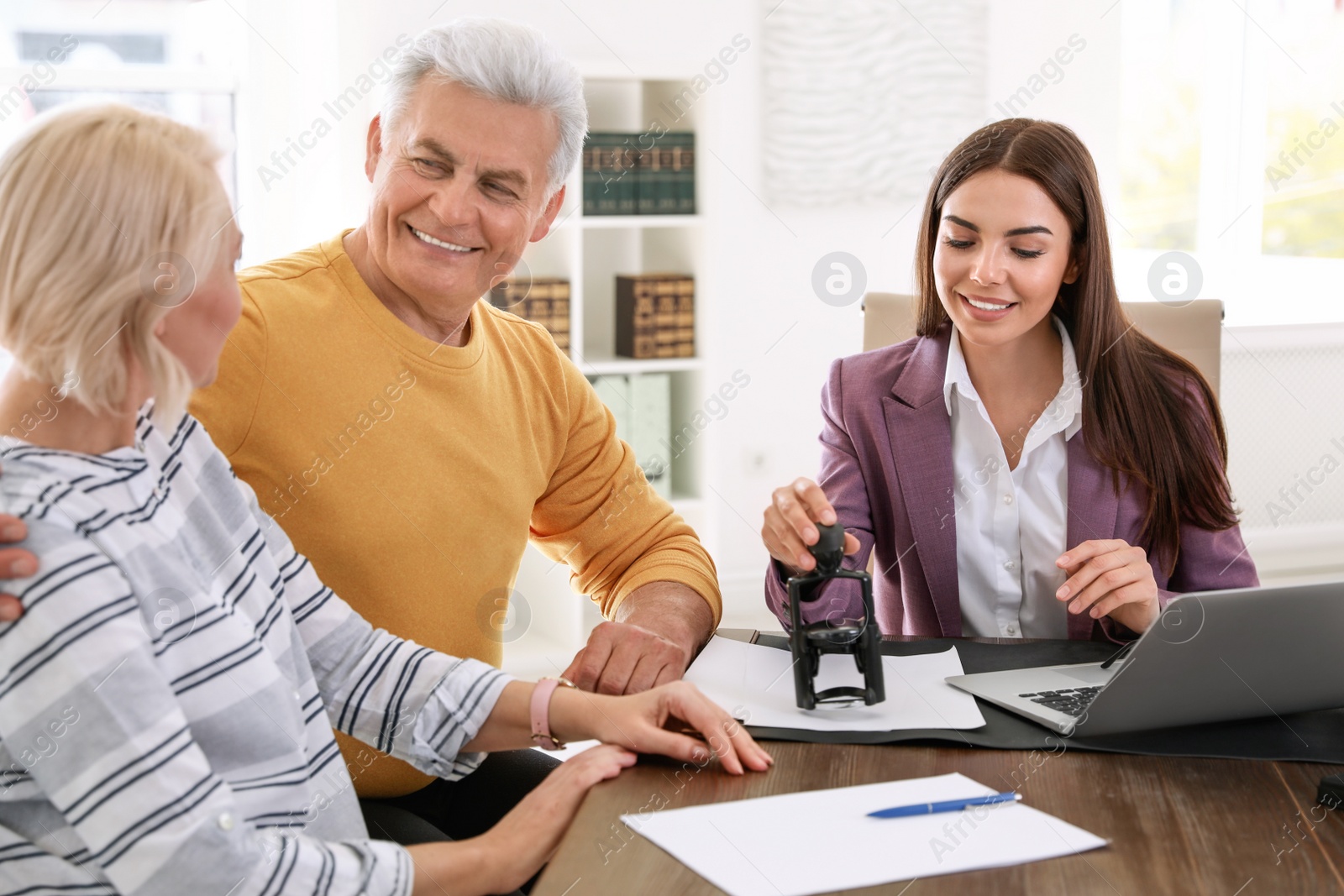 Photo of Female notary working with mature couple in office