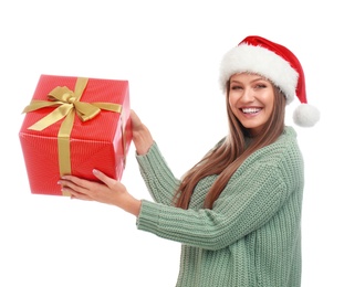 Happy young woman in Santa hat with Christmas gift on white background