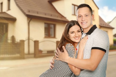 Dream home. Happy couple near big beautiful house. Space for text
