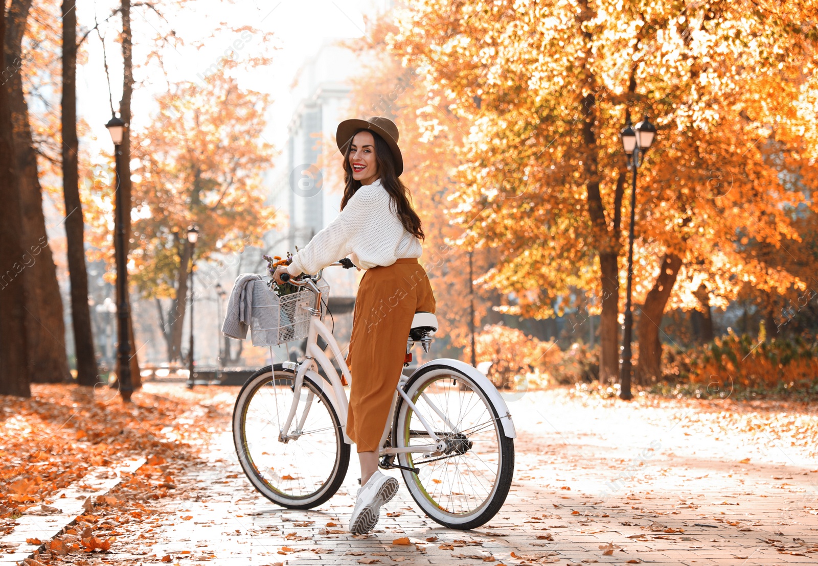 Photo of Beautiful happy woman riding bicycle in autumn park