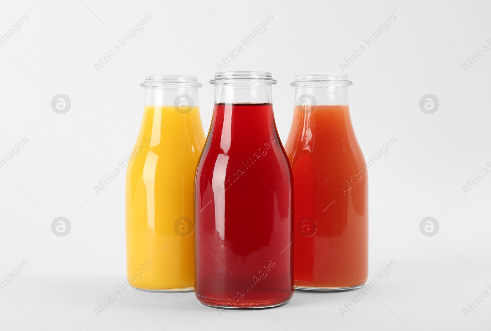 Photo of Bottles with delicious colorful juices on white background