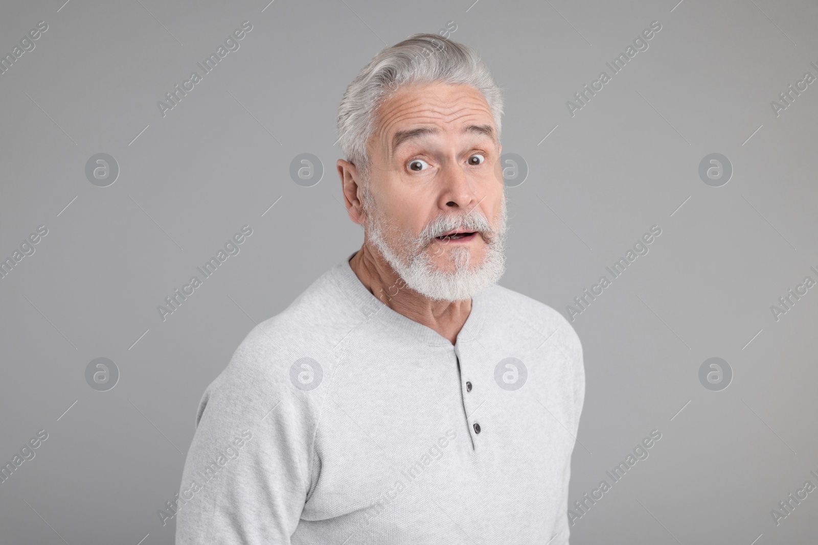 Photo of Portrait of surprised senior man on grey background