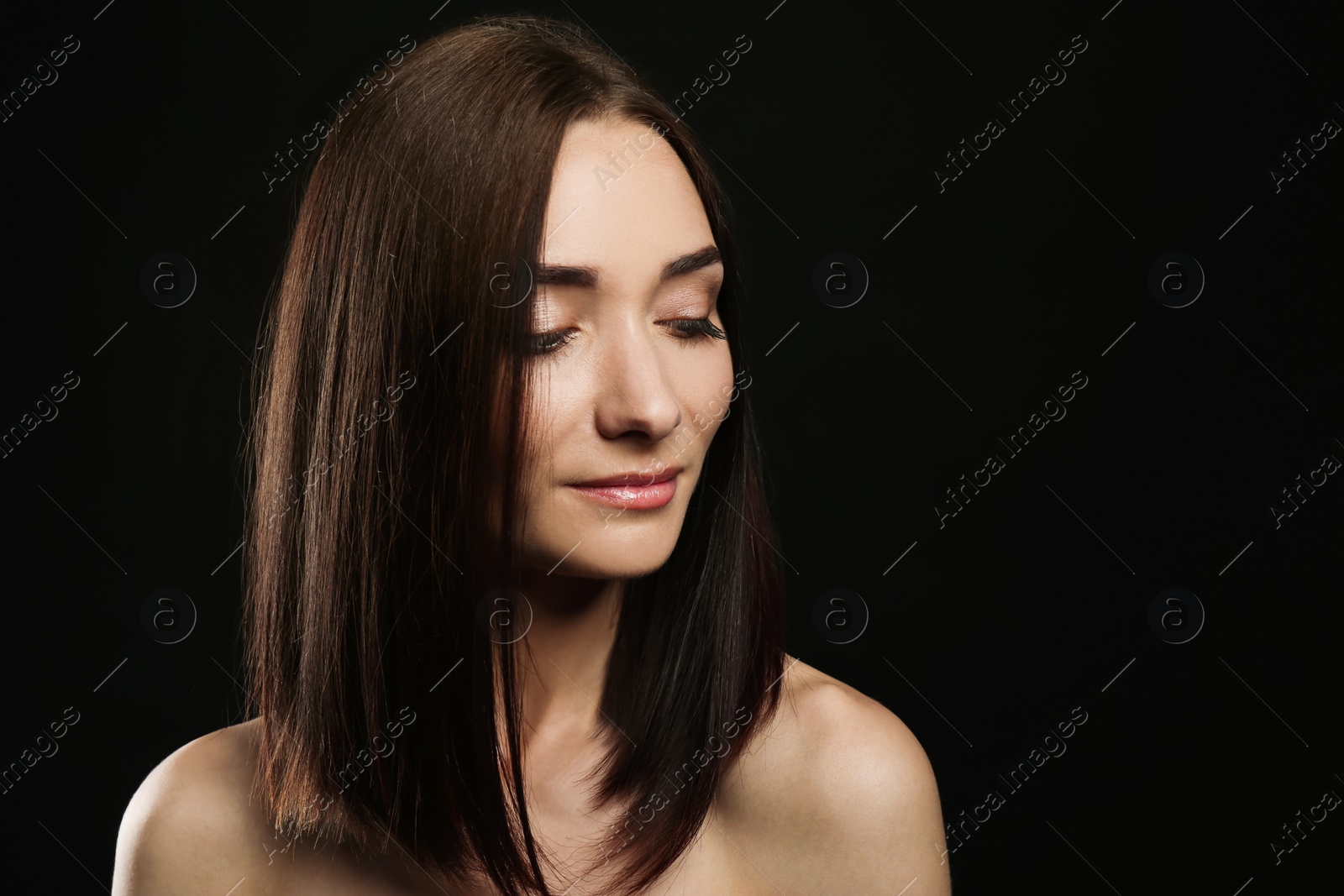 Photo of Portrait of pretty young woman with gorgeous chestnut hair on black background, space for text